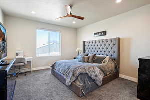 Bedroom featuring carpet floors, ceiling fan, baseboards, and a textured ceiling