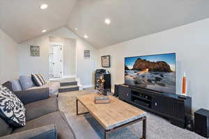 Living area with recessed lighting, carpet flooring, vaulted ceiling, and baseboards