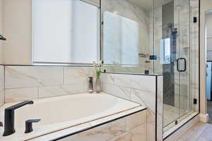 Bathroom featuring a garden tub and a shower stall