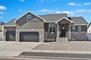 Craftsman house featuring stone siding, concrete driveway, and roof with shingles