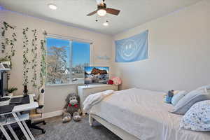 Carpeted bedroom with a textured ceiling and baseboards