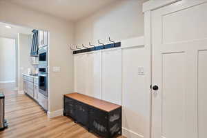 Mudroom with light wood-style floors and baseboards