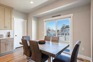 Dining room featuring a textured ceiling, light wood finished floors, and baseboards