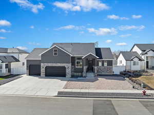 View of front facade with driveway, a shingled roof, fence, and a residential view