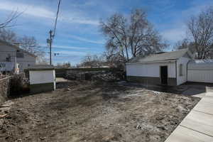 View of yard with an outbuilding and fence