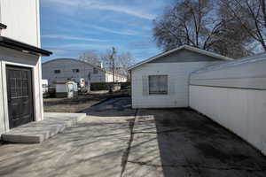 Exterior space featuring a storage shed, fence, and an outbuilding