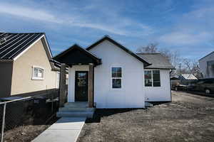 View of front facade featuring a shingled roof and fence