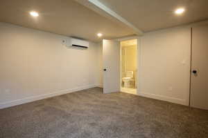 Finished below grade area with carpet floors, recessed lighting, and a wall mounted AC