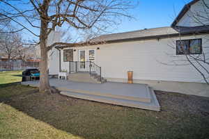 Rear view of house with french doors, a lawn, a patio area, and fence