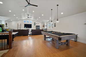 Playroom featuring billiards, baseboards, ceiling fan, vaulted ceiling, and light wood-type flooring