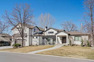 View of front of property with a garage, a shingled roof, driveway, a chimney, and a front yard