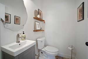 Bathroom featuring baseboards, vanity, and toilet