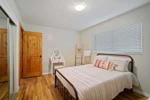 Bedroom featuring a closet, baseboards, and light wood finished floors