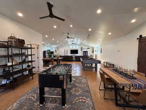 Game room featuring billiards, a ceiling fan, a barn door, lofted ceiling, and wood finished floors