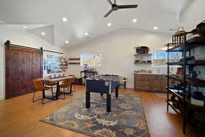 Recreation room with light wood-type flooring, ceiling fan, recessed lighting, and a barn door