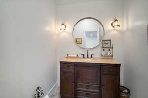 Bathroom featuring stone finish flooring, vanity, and baseboards