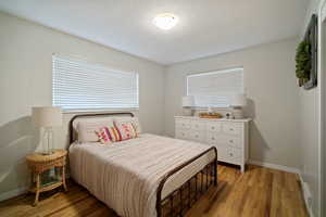 Bedroom with light wood finished floors and baseboards