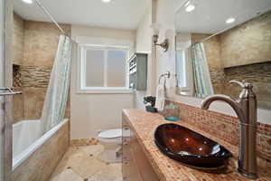 Full bathroom with tiled shower / bath, vanity, toilet, and recessed lighting