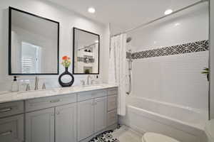 Full bath featuring shower / bath combination with curtain, recessed lighting, a sink, and double vanity