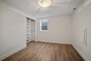 Unfurnished bedroom featuring a closet, a textured ceiling, baseboards, and wood finished floors