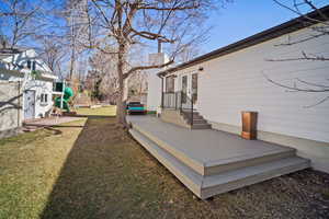 Wooden deck featuring a yard, french doors, a playground, and fence