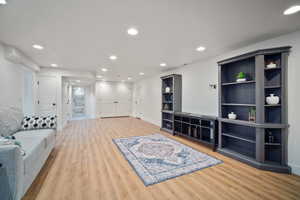 Living area featuring baseboards, wood finished floors, and recessed lighting