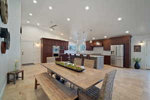 Dining area with high vaulted ceiling, recessed lighting, ceiling fan, and baseboards