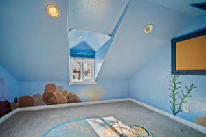 Bonus room featuring lofted ceiling, baseboards, visible vents, and carpet flooring