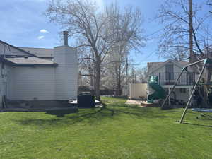 View of yard featuring a trampoline, fence, and a playground