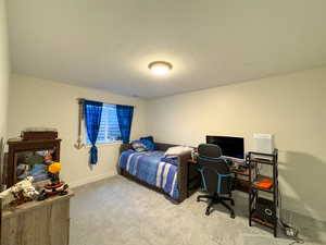 Bedroom featuring carpet and baseboards