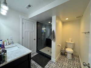 Bathroom featuring tile patterned flooring, visible vents, a shower stall, and toilet