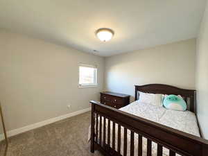 Bedroom with carpet, a textured ceiling, visible vents, and baseboards