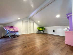 Bonus room with baseboards, hardwood / wood-style flooring, vaulted ceiling with beams, a textured ceiling, and recessed lighting