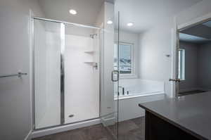 Full bath featuring a stall shower, vanity, and a bath