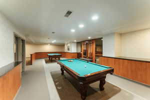 Recreation room with wainscoting, visible vents, and wallpapered walls