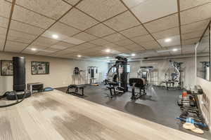 Workout area with baseboards, a drop ceiling, and recessed lighting