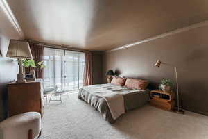 Bedroom with access to outside, crown molding, and carpet flooring