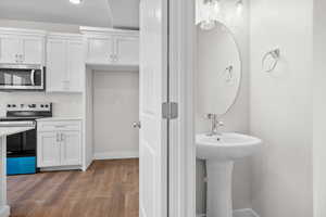 Half bath with light wood-type flooring and baseboards