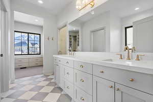 Primary bathroom with double vanity, recessed lighting, tile patterned floors and a gorgeous separate tub and shower.