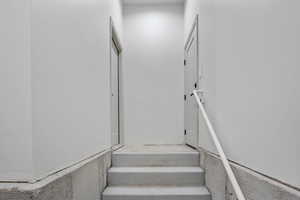 Stairs leading up and out of the basement. Two doors at the top of the stairs, one to the garage, one to the exterior of the home.