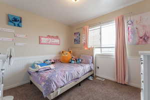 Bedroom with wainscoting, visible vents, and carpet flooring