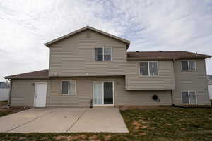 Rear view of house featuring a patio area and a yard