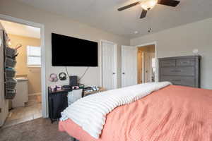 Bedroom featuring ceiling fan, baseboards, a closet, and light colored carpet