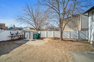 View of yard with a fenced backyard, a storage unit, and an outdoor structure