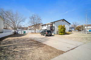 View of side of home featuring a storage shed, an outbuilding, and a fenced backyard