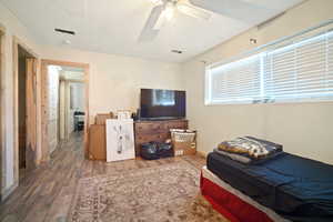 Bedroom featuring wood finished floors, visible vents, and a ceiling fan