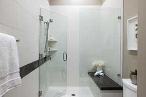 Bathroom featuring a shower stall and toilet