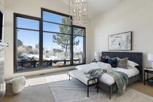 Bedroom with light carpet, an inviting chandelier, a towering ceiling, and visible vents