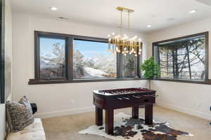 Recreation room featuring baseboards, visible vents, light colored carpet, a notable chandelier, and recessed lighting