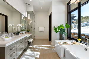 Full bath featuring recessed lighting, a freestanding bath, a stall shower, vanity, and baseboards